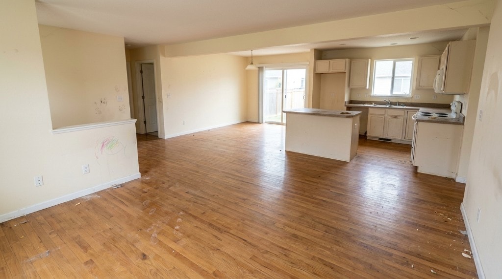 Apartment living area with crayon-marked walls and dusty floors before a Leina Cleaning move-out clean